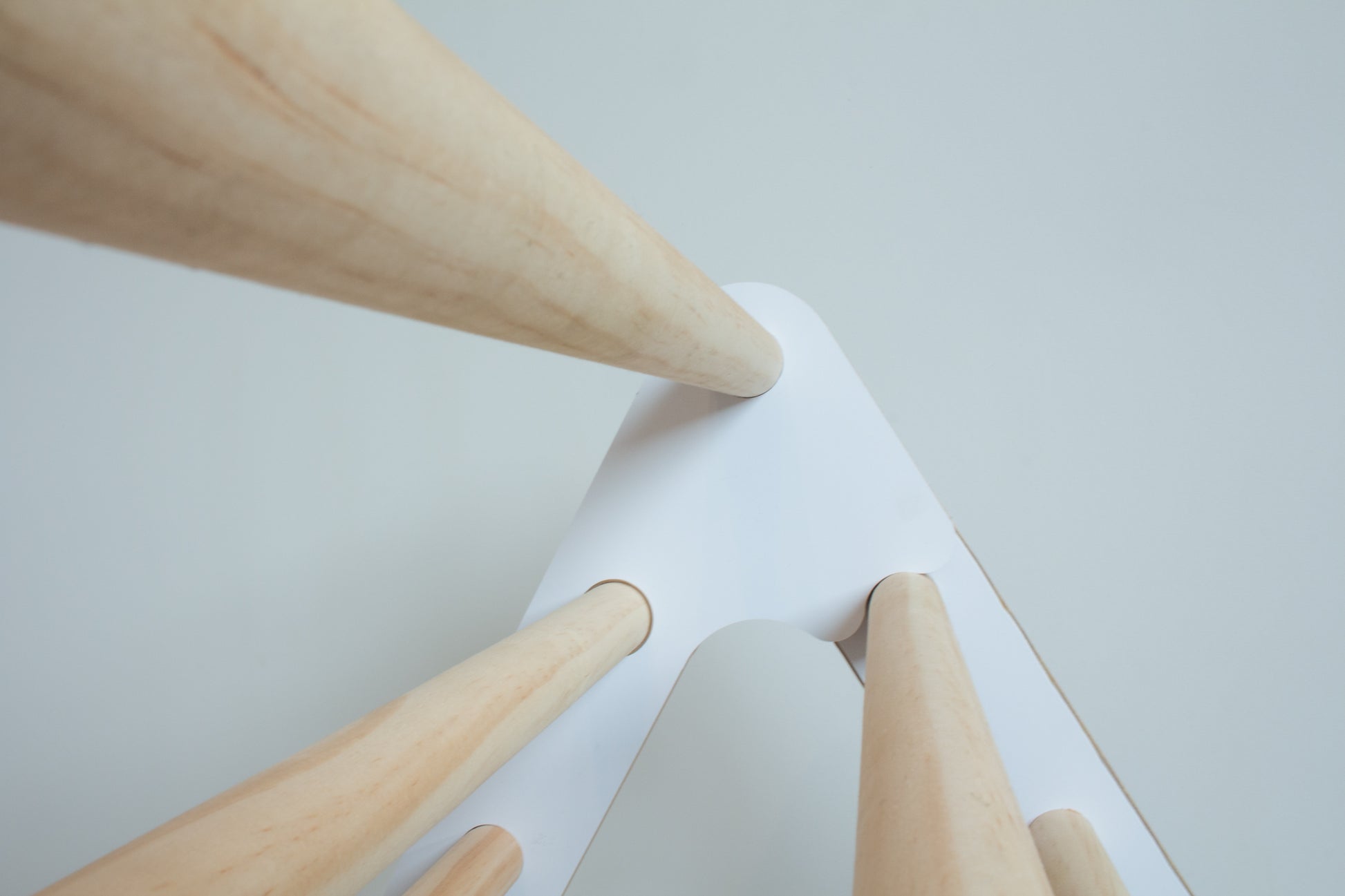 A close up image looking along the top rungs of a folding climbing frame in white and natural wood